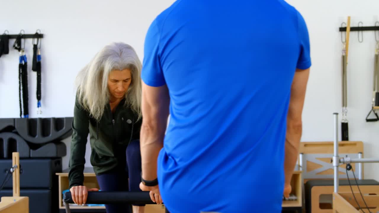 요가 4k를 수행하는 고령 여성들을 돕는 트레이너