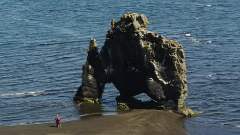 steady aerial drone view of the hivitserkur basalt sea stack in iceland