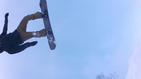 120 fps of snowboarder effortlessly doing a backflip over camera looking up