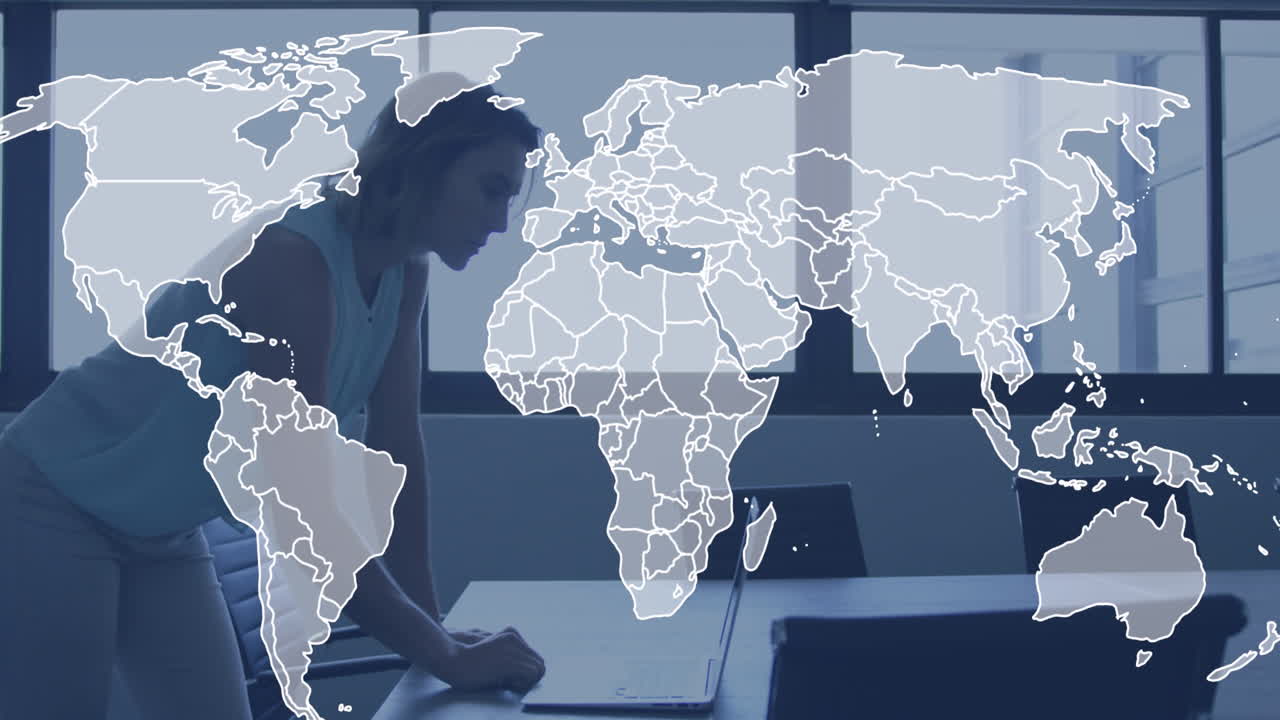 Animation of world map against caucasian woman using laptop at office