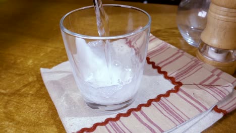 Agua-Mineral-Vertida-En-Un-Vaso,-El-Desayuno-De-La-Mañana,-Cámara-Lenta-Con-Seguimiento-De-Rotación.