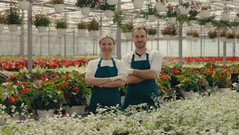two happy florists standing in a vibrant greenhouse