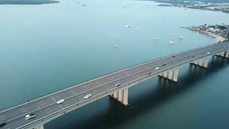 aerial: drone shot moving towards captain cook bridge as cars drive across to the city, in sydney, new south wales