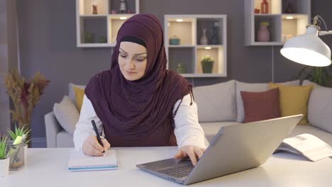 una mujer de negocios sonriente con hijab ama su trabajo y trabaja desde casa.