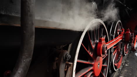 detail historic steam train wheels and puffing steam smoke engine