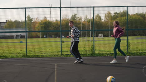 sports enthusiasts running in sports court, instructor visible in background, all dressed in sportswear, focus on their movement as they participate in physical training session outdoors