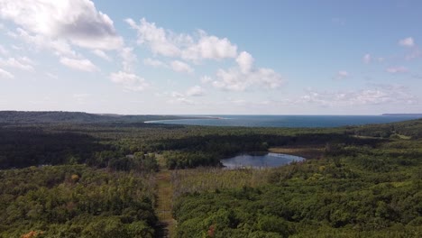 Grüne-Landschaft-Umgeben-Glen-Lake-Mit-Sleeping-Bear-Dunes-National-Lakeshore-Im-Hintergrund-In-Der-Nähe-Von-Glen-Arbor,-Michigan,-USA