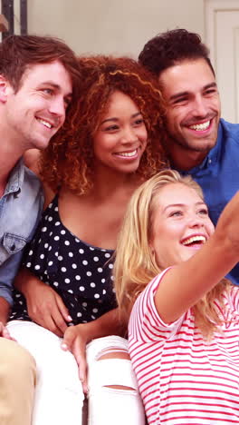 amigos sonrientes tomando selfies con su teléfono inteligente