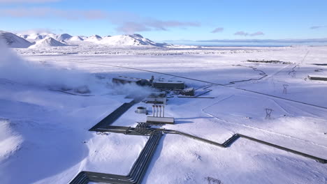 a geothermal power plant in a snowy icelandic landscape, steam rising, clear blue sky, aerial view