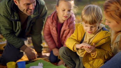 family enjoying a picnic in the park during autumn