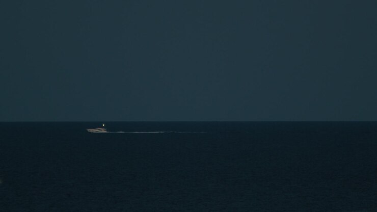 Small Boat Moves In The Night In The Ocean In Summer On The Horizon