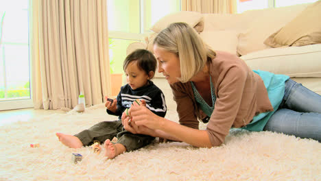 Madre-Joven-Jugando-Con-El-Bebé-En-La-Alfombra