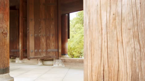 Slide-shot-of-giant-wooden-gate-entrance-for-a-temple-in-Kyoto,-Japan-4K-slow-motion