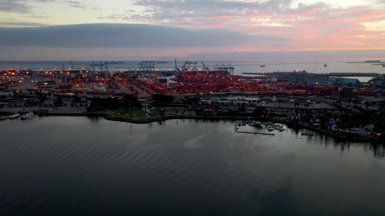 Long Beach Harbour California, USA. Beautiful aerial shot of houses, trees, blue water and the lighthouse. Establishing shot of the area at dusk with pink clouds