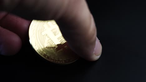 rich golden bitcoin cryptocurrency being picked up from a dark background