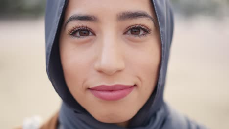 close-up portrait of a cheerful muslim woman in a hijab, smiling and laughing with her eyes closed