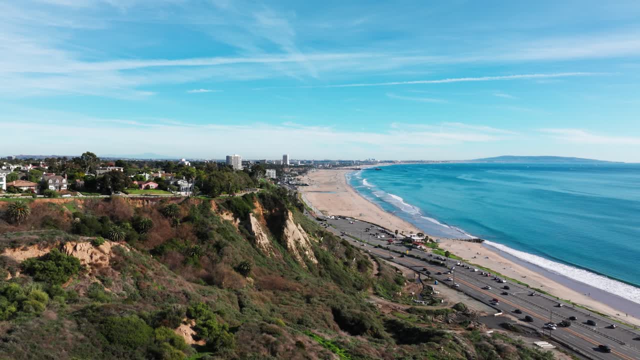 Drone shot revealing Santa Monica Beach and Pier on a sunny day