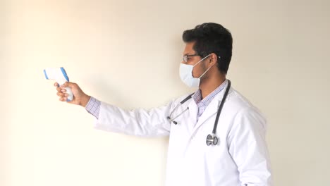 doctor using an infrared thermometer to check a patient's temperature