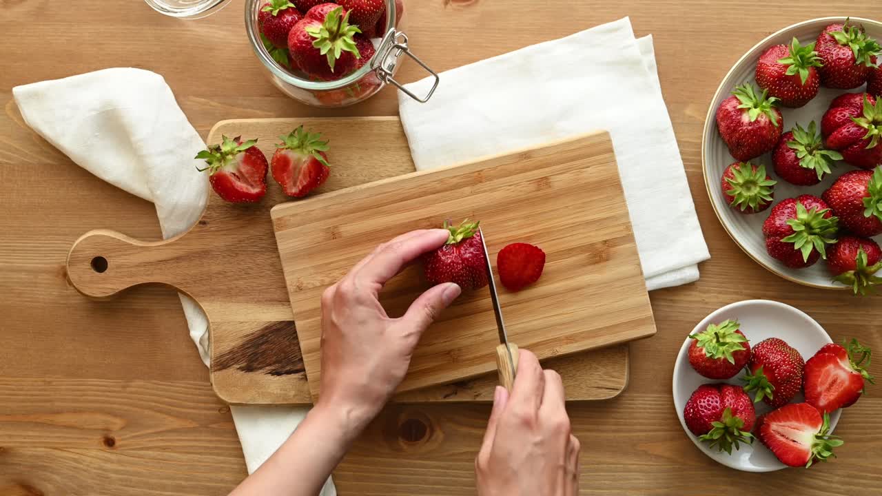mujer anónima cortando fresas fresas en la tabla de cortar