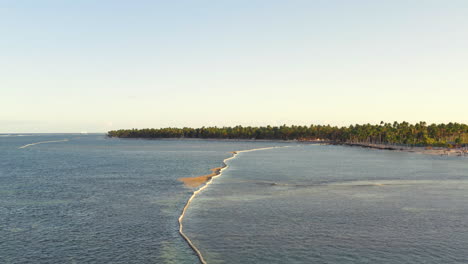 Flying-along-a-floating-boom-preventing-algae-and-pollution-from-washing-up-on-the-beach,-aerial