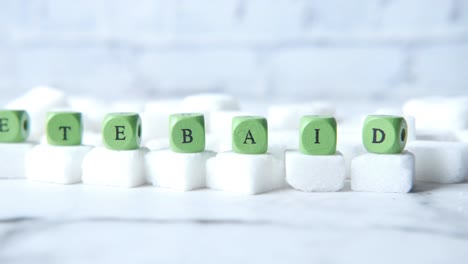 letras de madera verdes que escriben tebaid en cubos de azúcar