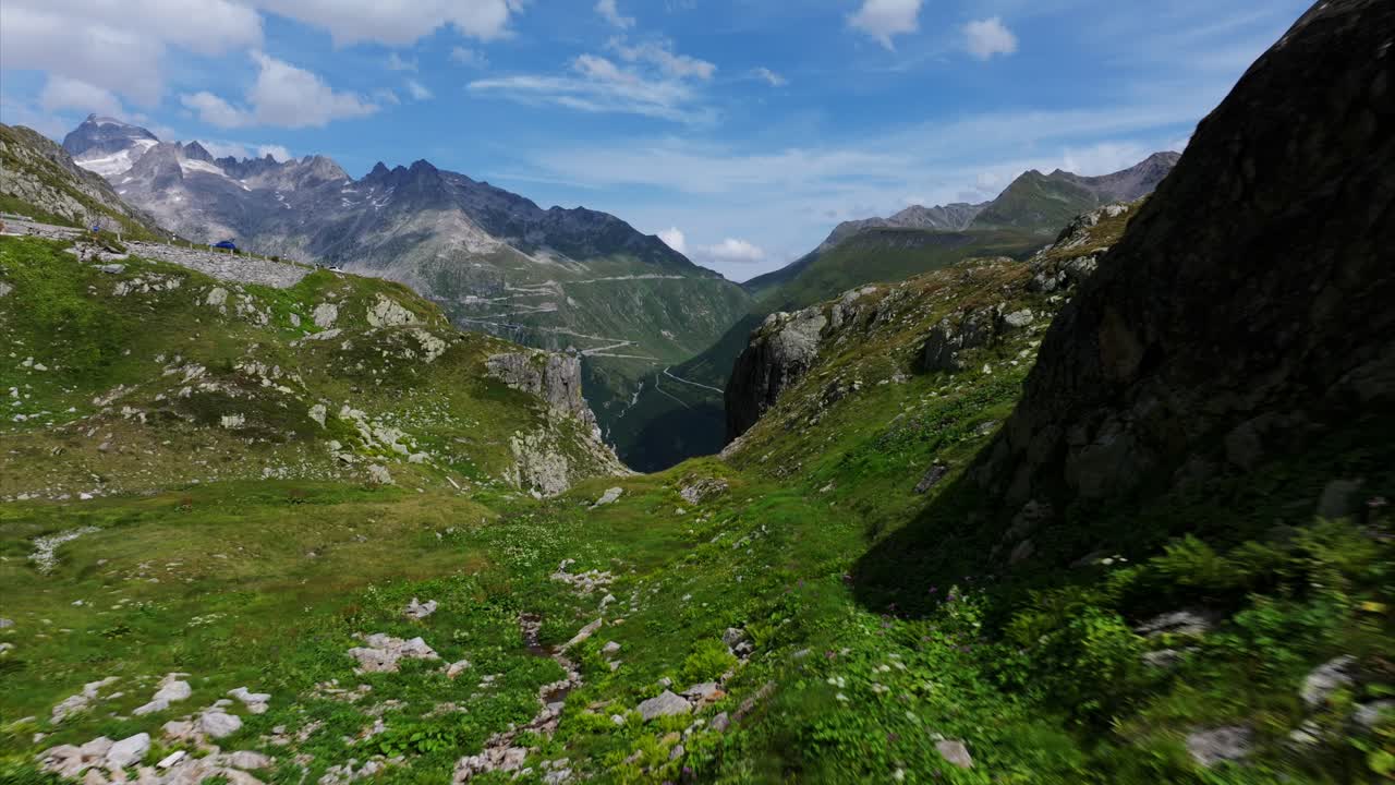 Aerial view of Grimsel Pass, showcasing its winding roads carved through the majestic Swiss mountains. Push Forward