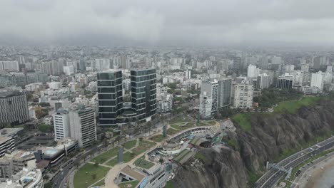 panorámica aérea sobre la densa y neblinosa ciudad costera del pacífico de miraflores, perú