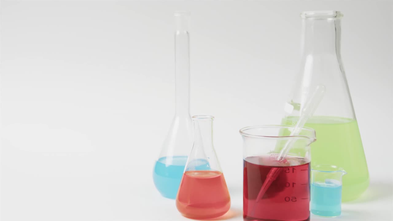 líquidos de color en frascos sobre fondo blanco con espacio para copiar, cámara lenta