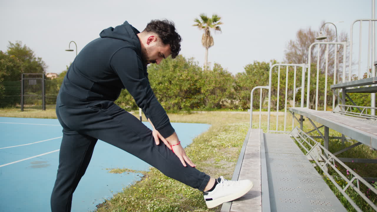 Basketball Player Stretches His Legs Outdoors
