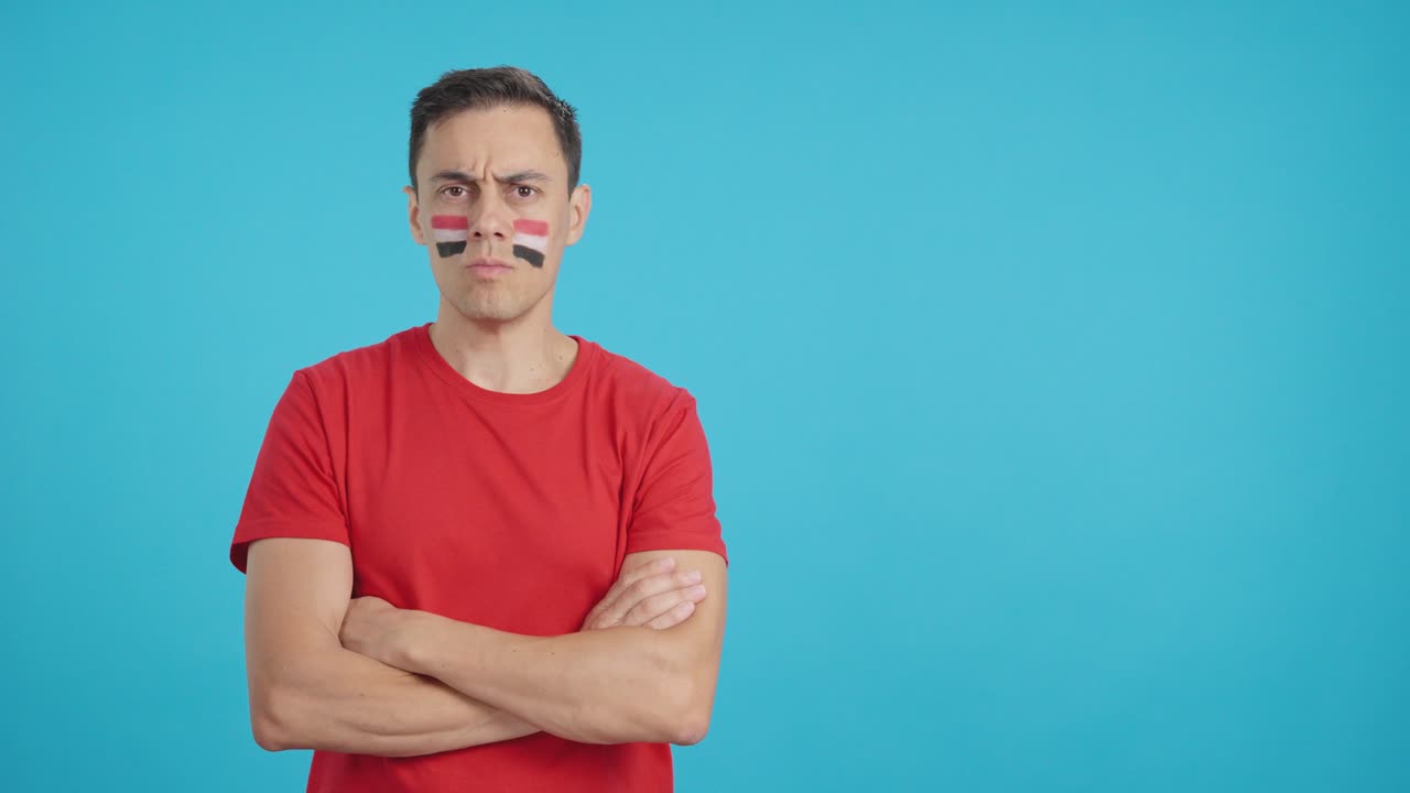Dignified and serious man with egyptian flag painted on face