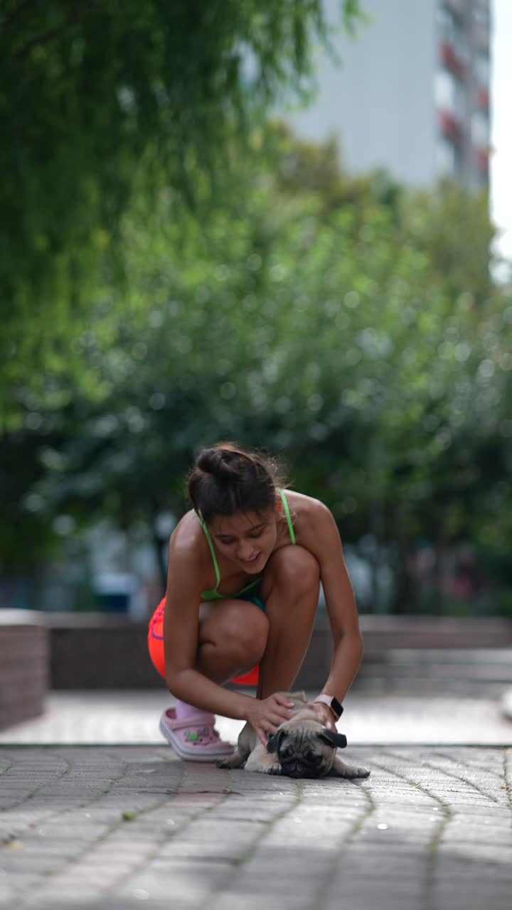 mujer jugando con su pug en un parque