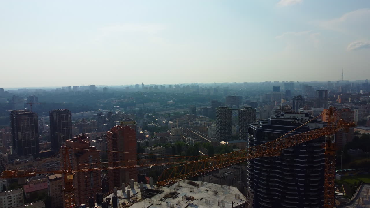 Bright sunny day in Ukraine capital Kyiv. Aerial cityscape 4k. Panoramic view. Construction cranes in foreground.