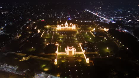 aerial view of mysuru palace illuminated at night, surrounded by sparkling city lights. highlights the grandeur and cultural richness of karnataka's iconic royal landmark. india.