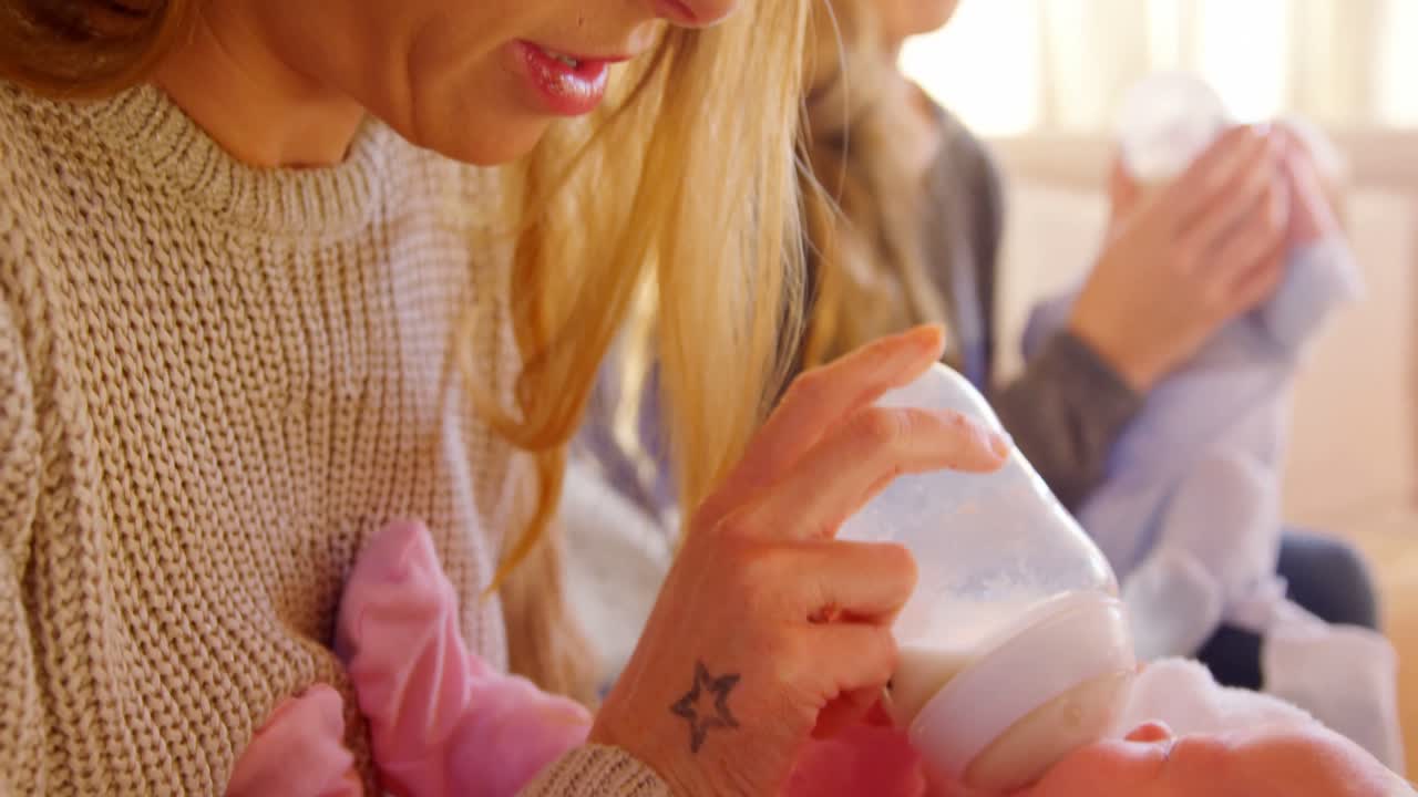 레즈비언 커플이 집에서 아기에게 먹이를 주는 4k