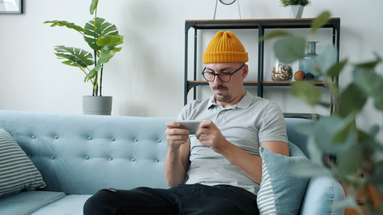 Man playing mobile game on a couch
