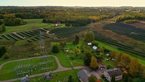 autumn aerial view of rural power station and solar farm near winding country road