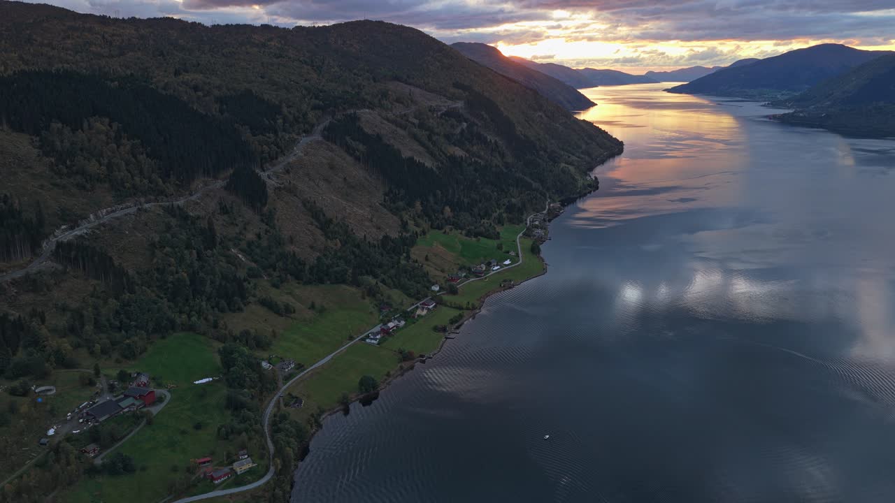Luz da hora dourada sobre a tranquila aldeia de Nordfjordeid, vista de cima.