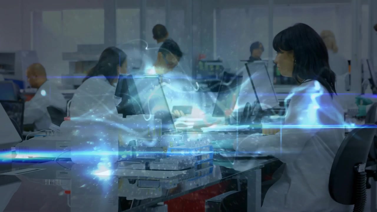 Blue wave drifting across lab bench activating team analyzing data with analyst pointing monitors
