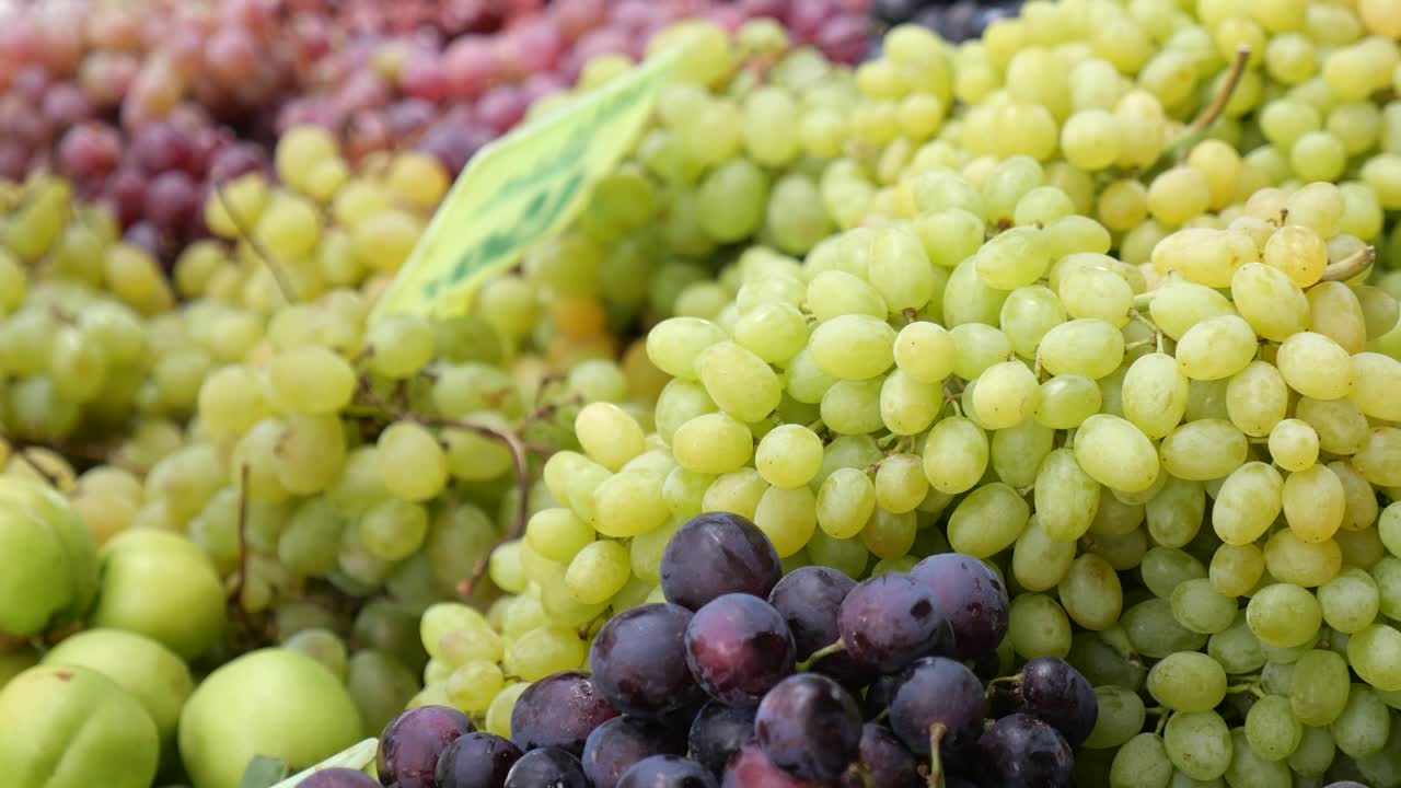 Abundance of Fresh Green and Purple Grapes at a Market