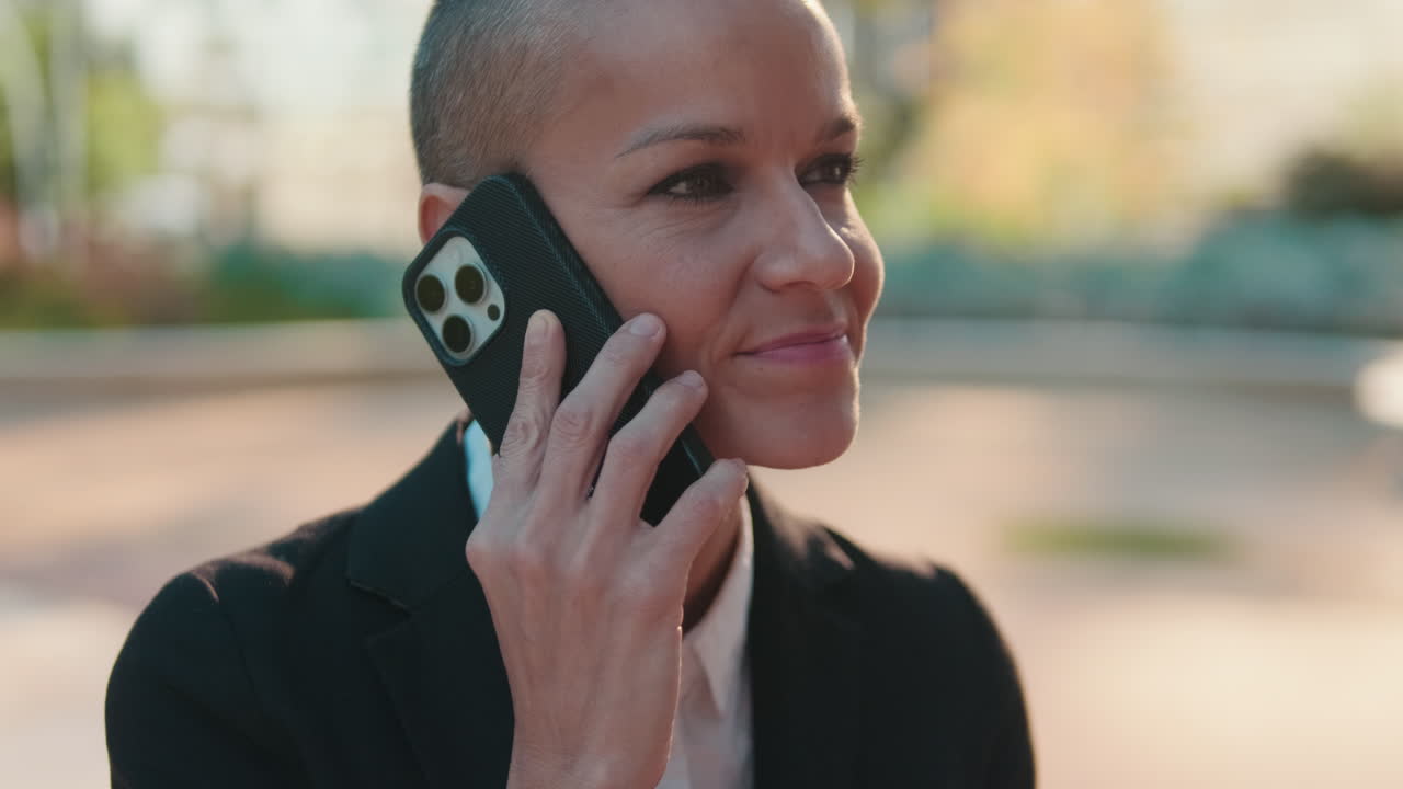 Smiling Woman with Short Hair Talking on Smartphone Outdoors