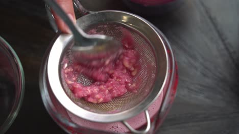 la creación de un cóctel de granada con jugo de granada fresco y semillas de ron jarabe de lima y ingredientes frescos