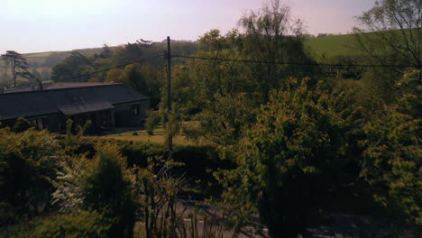 A-drone-shot-flying-out-of-living-room-double-doors-to-the-garden-and-landscape-beyond