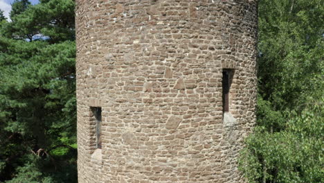 closeup shot of an old folly in england, shot moving upwards to reveal the horizon