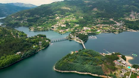 Imágenes-Aéreas-Del-Puente-De-Caniçada-Sobre-El-Río-Caldo,-Gerês,-Norte-De-Portugal,-Bañadas-Por-El-Sol-Con-Vistas-Reflectantes-Al-Lago.