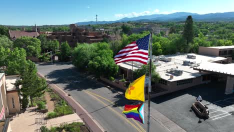 banderas estadounidenses, de nuevo méxico y del orgullo ondeando en el centro de santa fe, nm