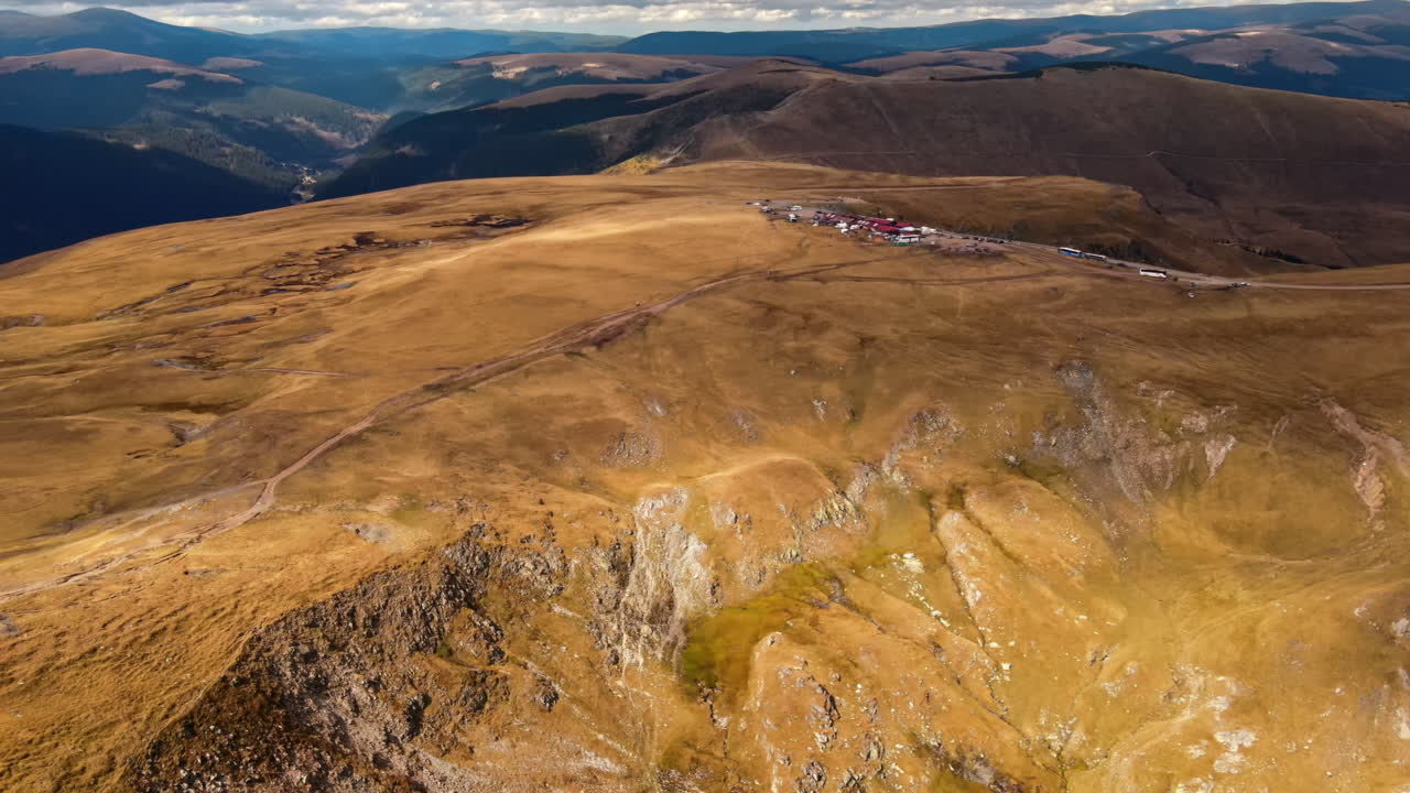 Aerial drone view of nature in Romania. Carpathian mountains, sparse vegetation, Transalpina road with camp