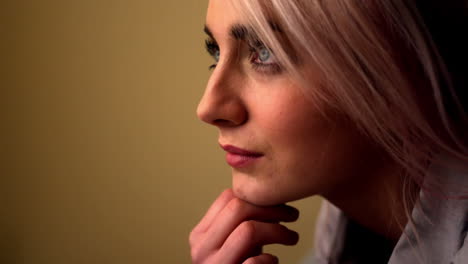 Thoughtful-young-blonde-sitting-on-her-bed