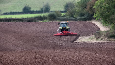 Ein-Bauer,-Der-Im-Herbst-In-Der-Landschaft-Von-Worcestershire,-England,-Einen-Traktor-Fährt-Und-Ein-Gepflügtes-Feld-Harkt