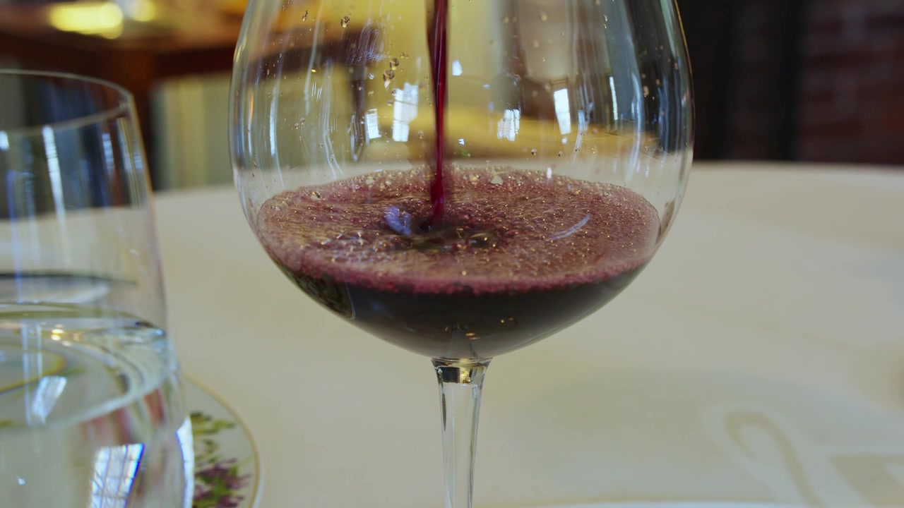 Vino versato a tavola in un ristorante. Tovaglia bianca