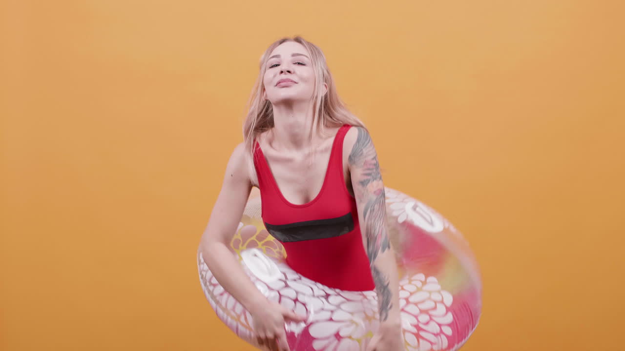 Woman in Red Swimsuit Posing with Swim Ring